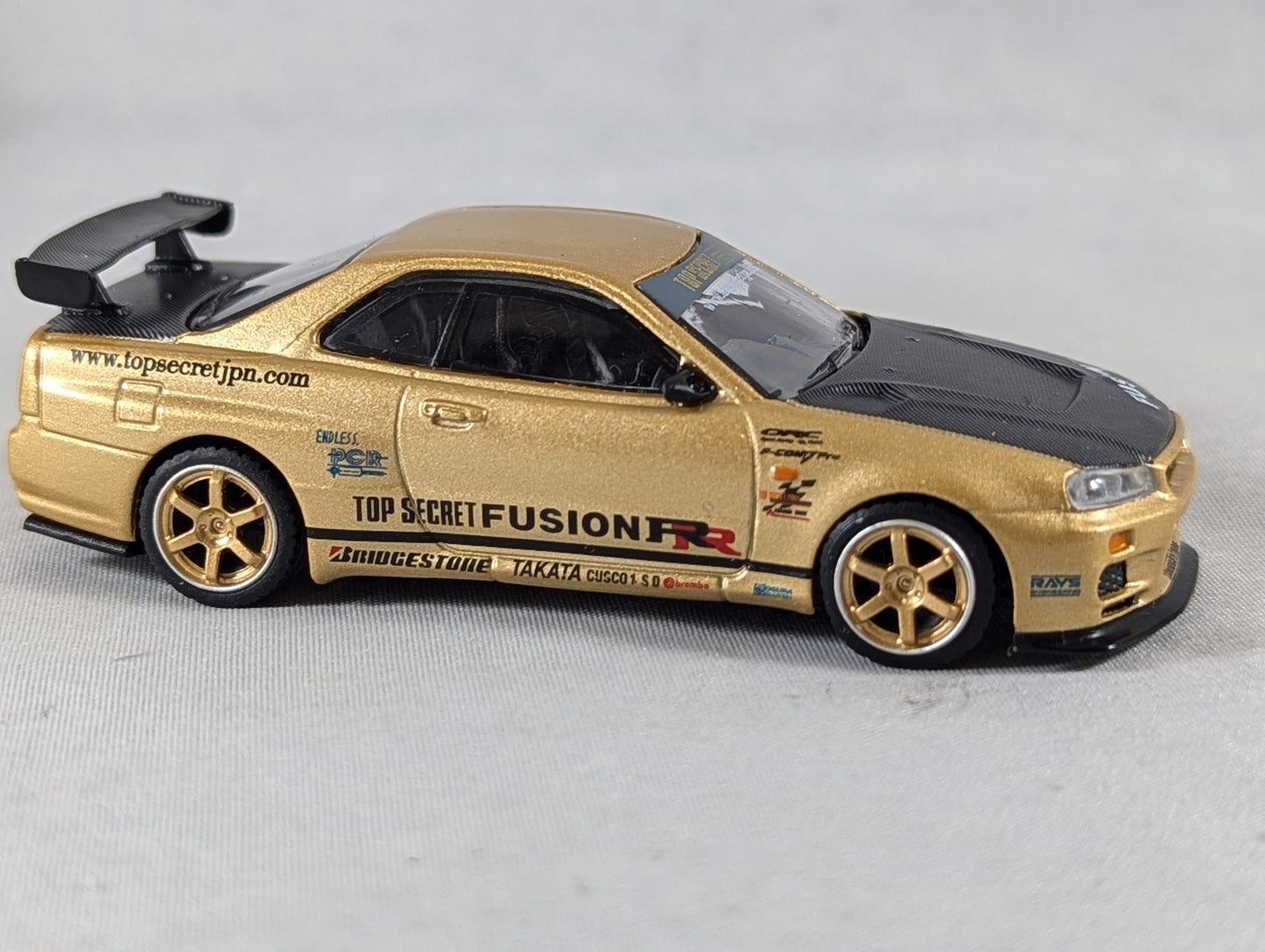 Mini GT Nissan Skyline GT-R (R34) Top Secret Gold