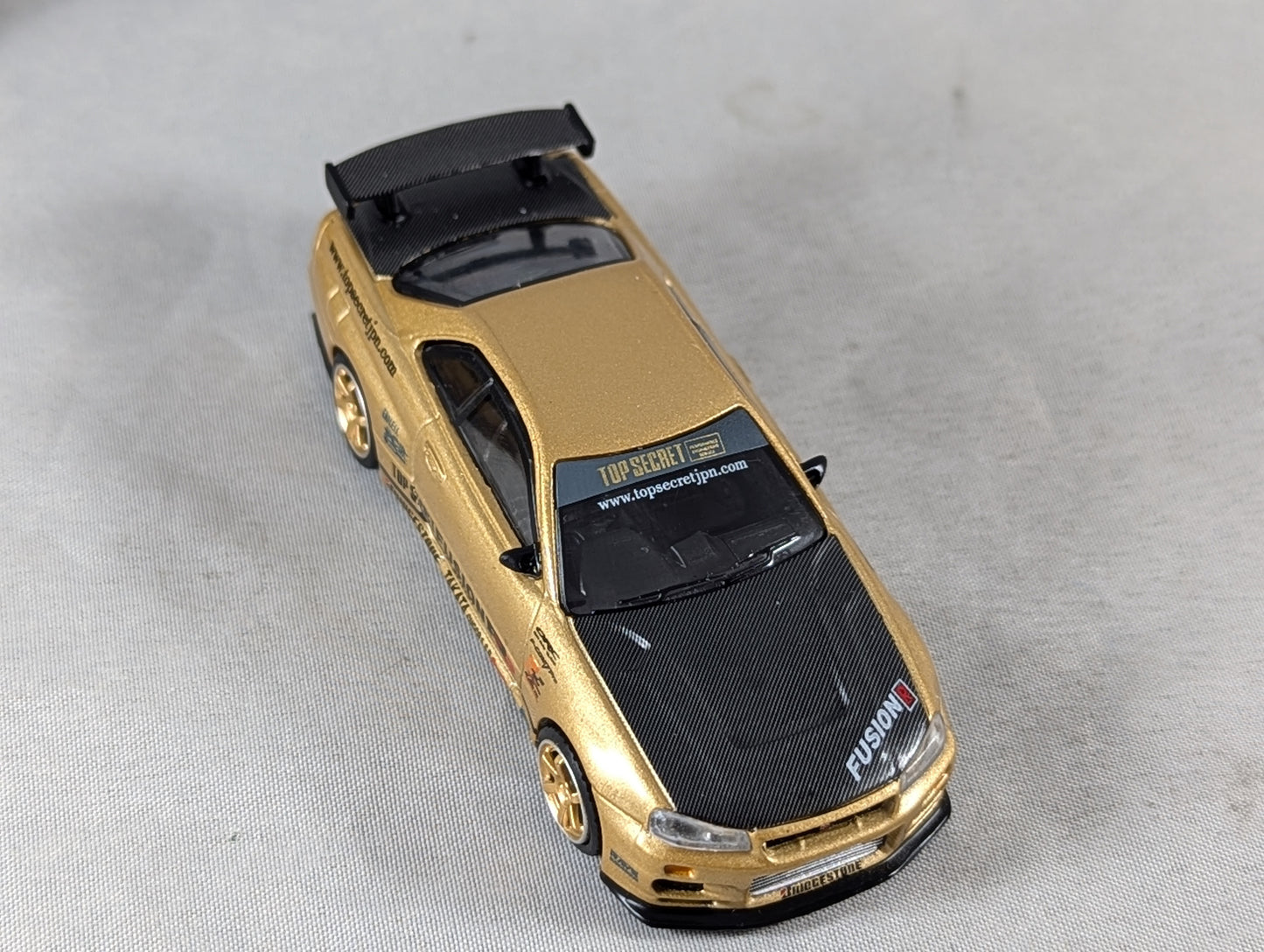 Mini GT Nissan Skyline GT-R (R34) Top Secret Gold
