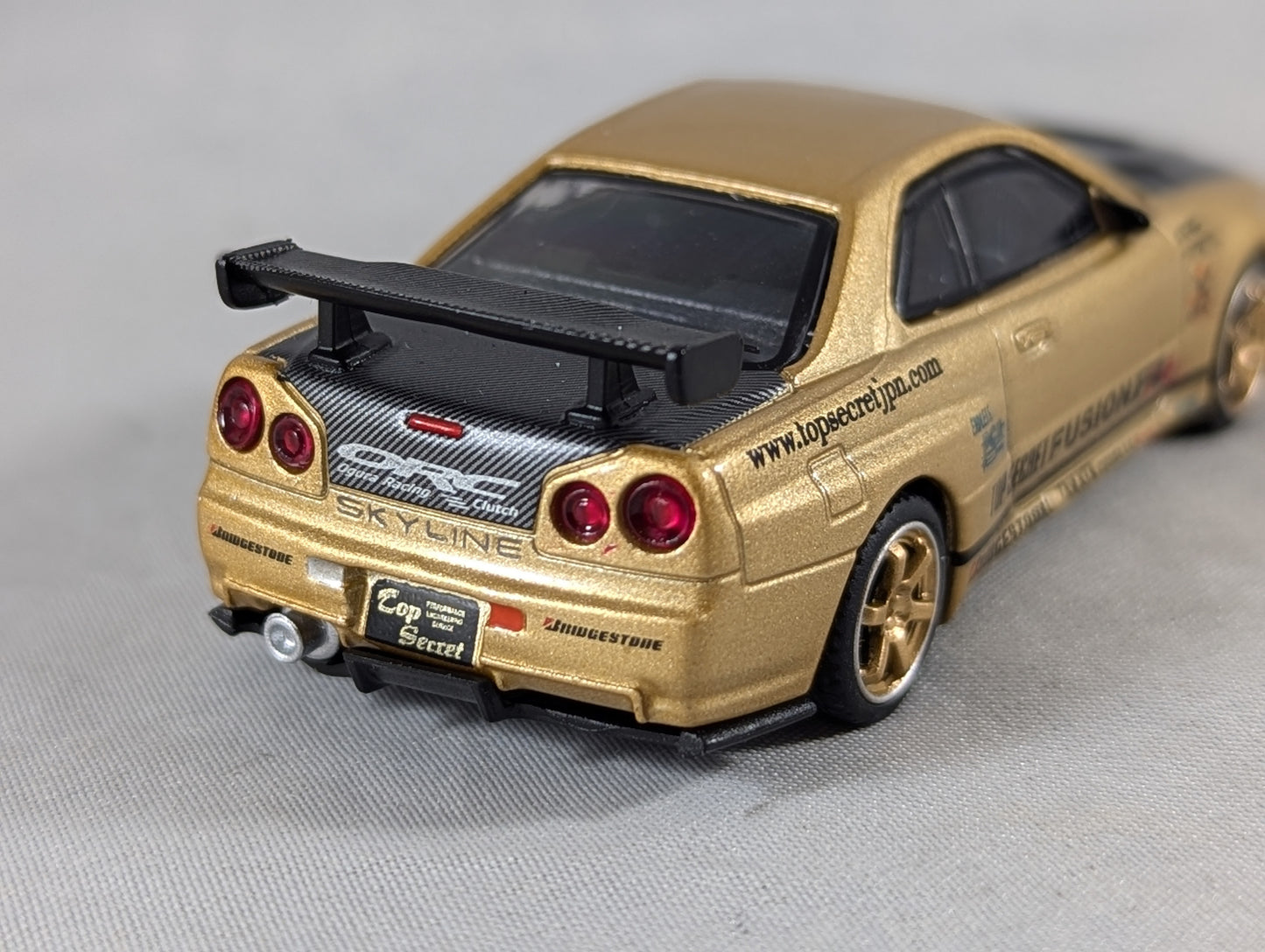 Mini GT Nissan Skyline GT-R (R34) Top Secret Gold