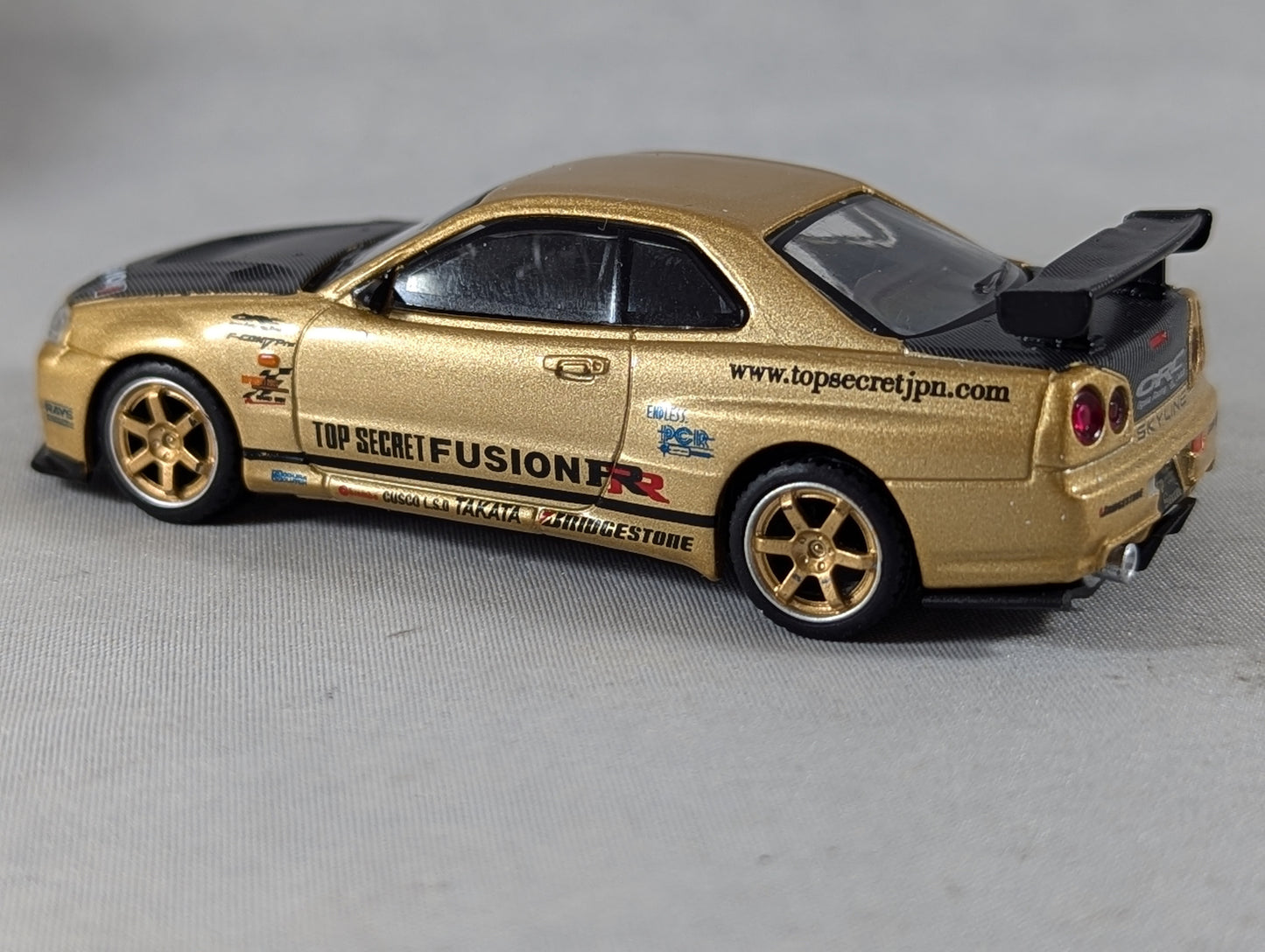 Mini GT Nissan Skyline GT-R (R34) Top Secret Gold